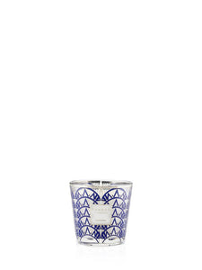 Candle in a glass container with blue geometric pattern on a white background