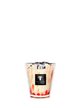 Candle in a glass container with a visible brand label on a white background