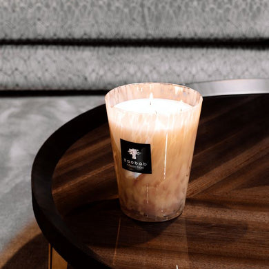Candle on a wooden table with a blurred sofa in the background
