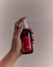 hand holding a room spray bottle