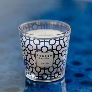 Candle with a patterned label on a blue textured surface