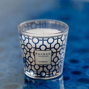 Candle with a patterned label on a blue textured surface