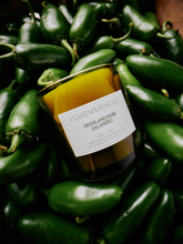 Flamingo Estate Highland Park Jalapeño candle on a bed of Jalapeño chilies