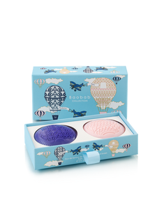 Two bath soaps, one purple and one pink, in a decorative box with airplane and hot air balloon designs on a white background.