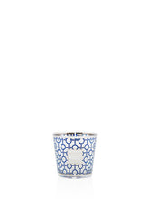 Candle in a decorative glass holder with blue and white pattern on a white background