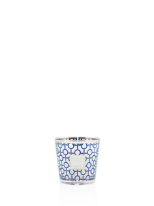 Candle in a decorative glass holder with blue and white pattern on a white background