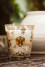 Decorative candle with intricate gold designs on a wooden surface