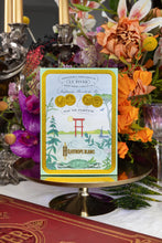 Decorative product packaging with floral arrangement and candle in the background