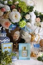 Decorative setting with flowers, a statue, and a perfume bottle on a table.