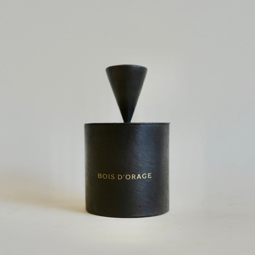 Mad et Len Lemaire Bois d'Orage scent candle in a black metal container, gold appliqué. Cone Shape candle cap cover. 