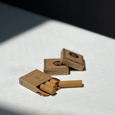 Three small cardboard boxes with palo santo pressed incense on a white surface.