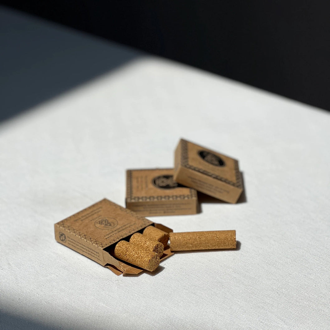 Three small cardboard boxes with palo santo pressed incense on a white surface.