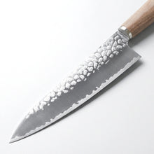 Chef's knife with a textured blade and wooden handle on a white background