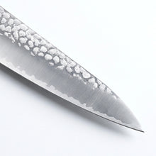 Close-up of a knife blade with a white handle on a light gray background