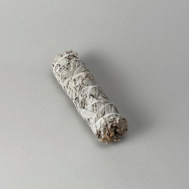 Rolled sage smudge stick on a gray background