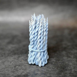 Nepali Cedar Rope Incense strands wrapped in light blue paper. 