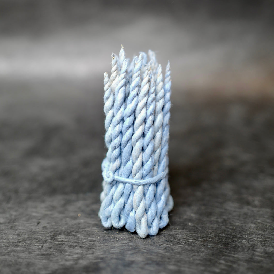 Nepali Cedar Rope Incense strands wrapped in light blue paper. 