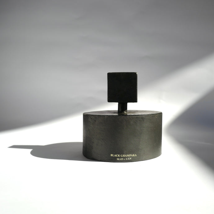 Black cylinder metal Mad et Len Bougie Totem Square Grande - Black Champaka with square totem lid handle.