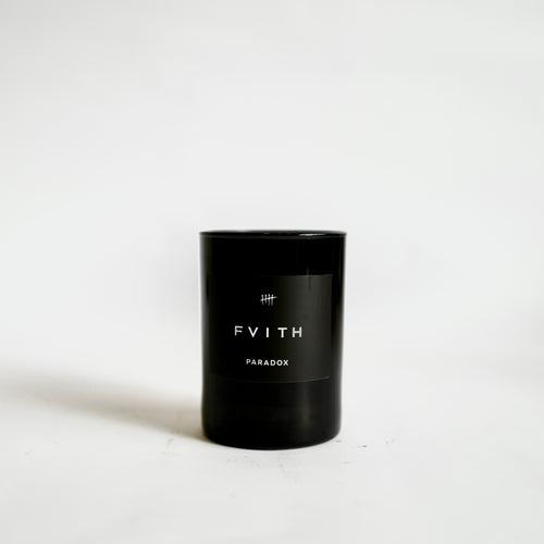 Paradox Fragrance Candle in black glass container and labeling. 