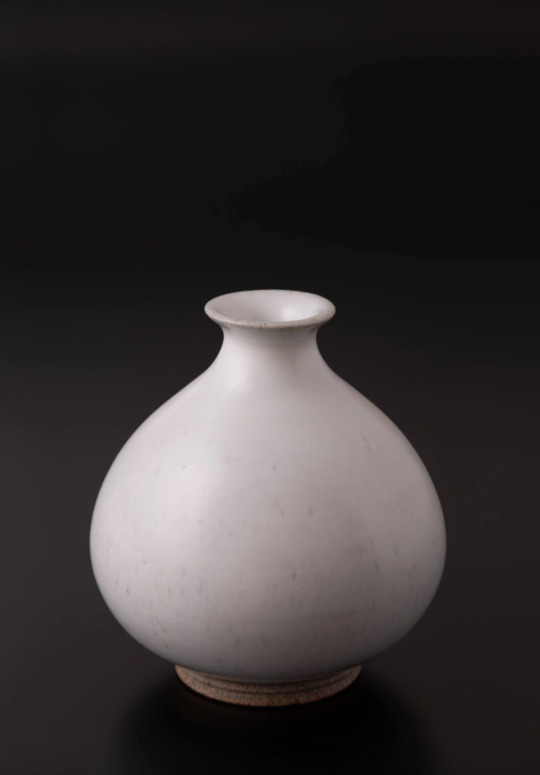 Bulbous shape Japanese Pottery ZANSETSU / Ichirinzashi in a black background. Snow White glaze color with coin size opening at the top. 