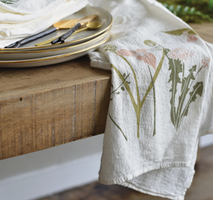 June and December Healing tea Towel draping over a wood table. 