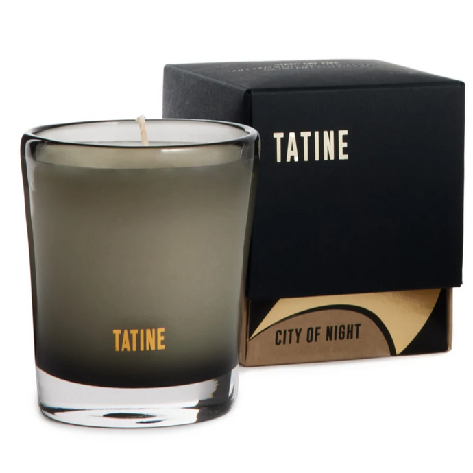 Tatine City of Night Candle in a smoked glass container. Brand box packaging behind candle. 